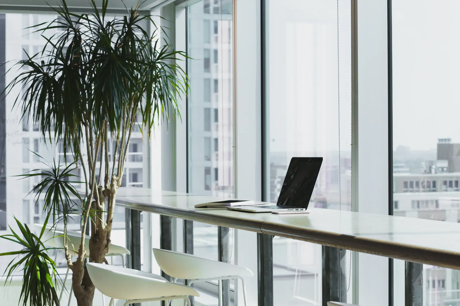 An empty coworking floor with long desks and daylight.